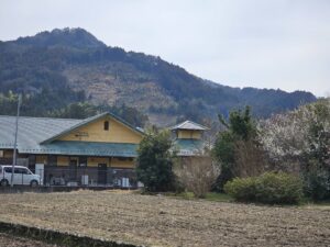 鳩友園の建物の外観と周囲の山並み