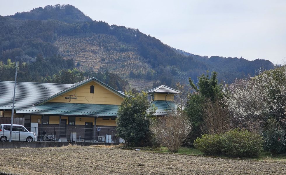 鳩友園の建物の外観と周囲の山並み